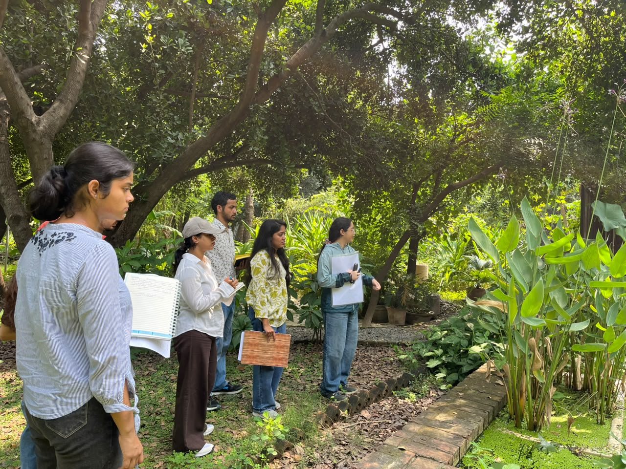 Researchers recording observations beside the water body at Farm8
